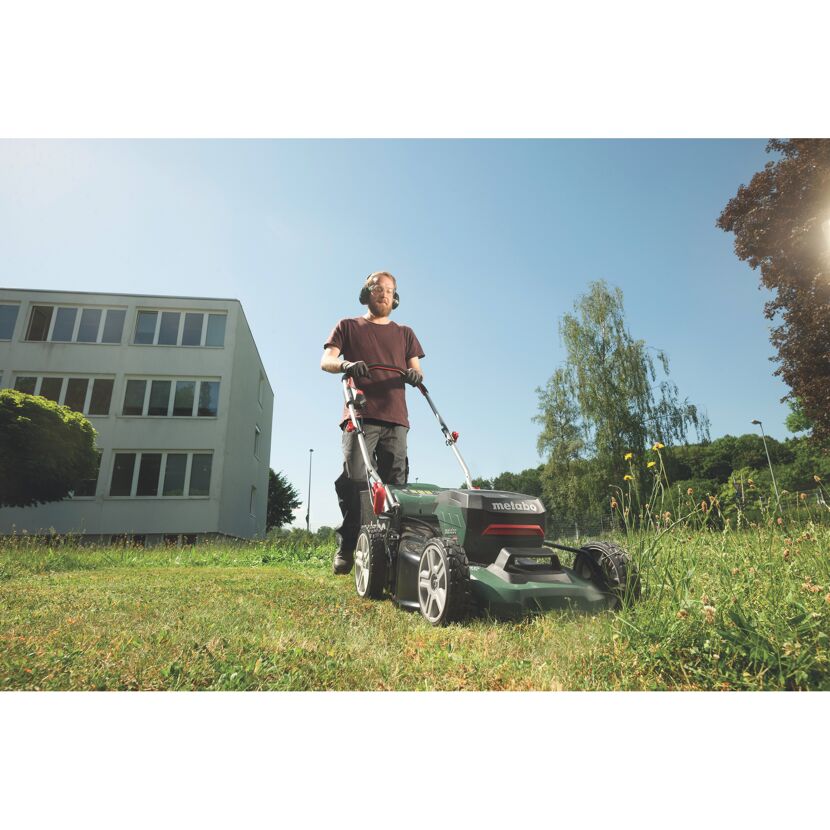 Person mäht Rasen mit einem Metabo Rasenmäher.