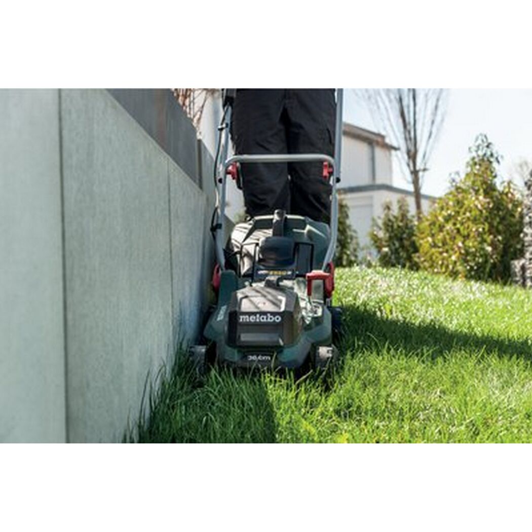 Person mäht Rasen mit einem Akku-Rasenmäher von Metabo.