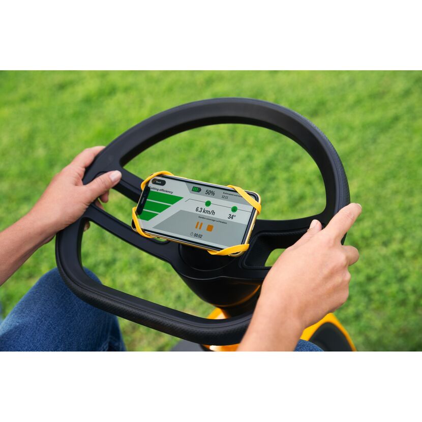 Person steuert einen Rasentraktor mit Smartphone-App.