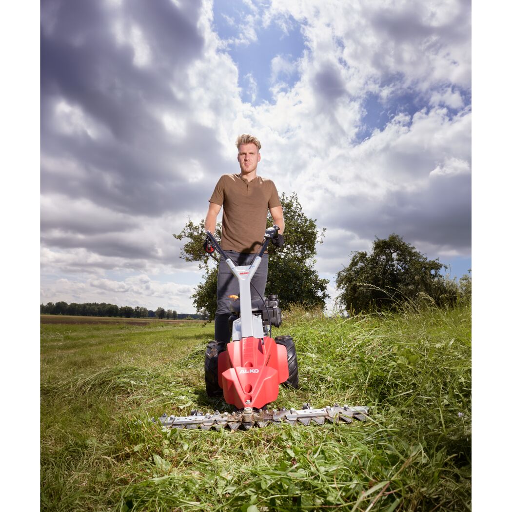Person mäht hohes Gras mit Balkenmäher