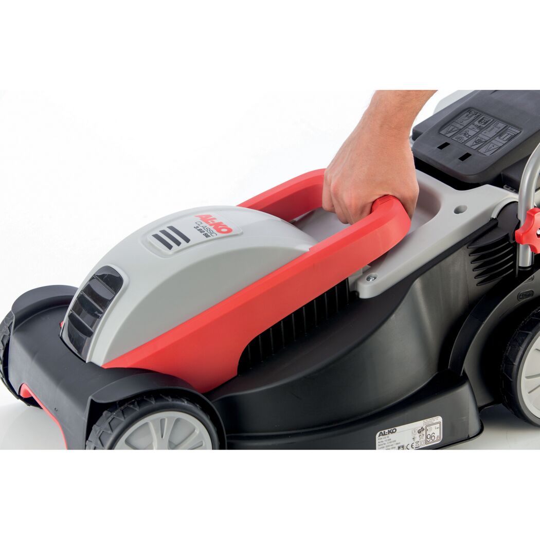 Person schiebt Elektro-Rasenmäher