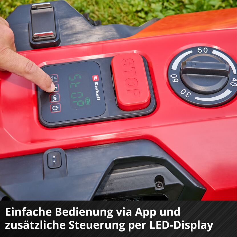 Person bedient Display am Mähroboter
