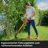Person trimmt Rasen mit Rasentrimmer