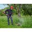 Person mäht hohes Gras mit Freischneider