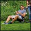 Person sitzt im Gartenstuhl und nutzt Smartphone