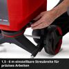 Person stellt Streubreite an einem Streuwagen ein