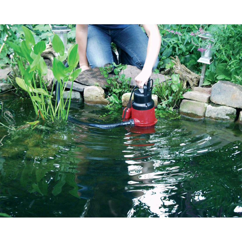 Person verwendet Tauchpumpe im Gartenteich.