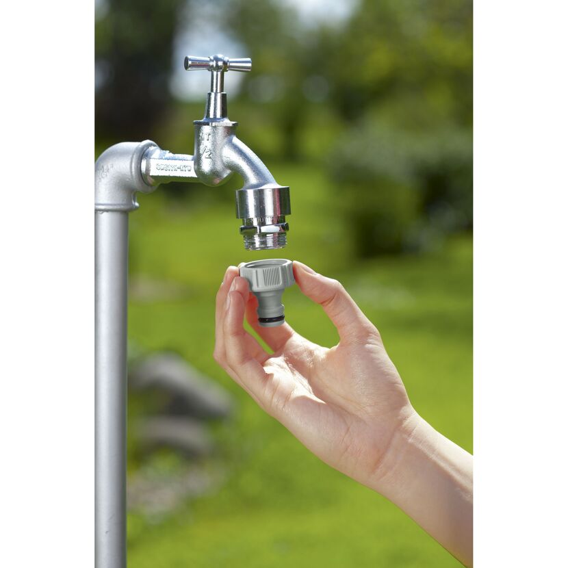 Person hält Hahnverbinder G 1/2" an Wasserhahn