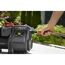 Person befestigt einen Gartenschlauch an einer Gartenpumpe.