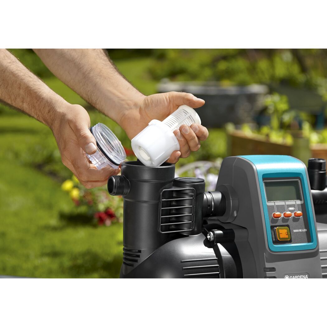Person setzt Filter in GARDENA Hauswasserautomat ein