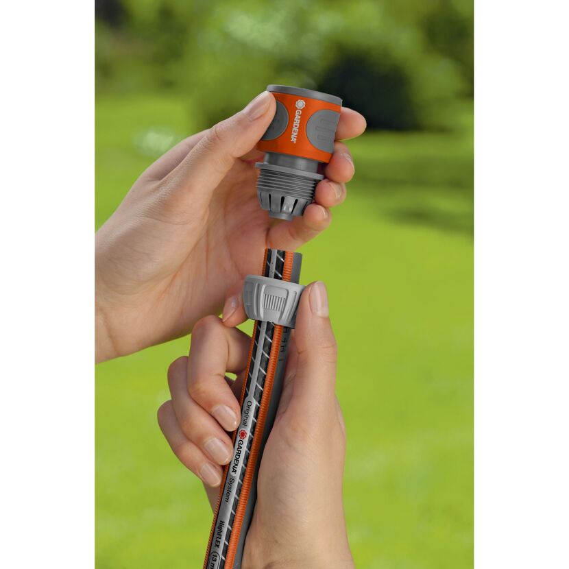 Person verbindet zwei Gartenschläuche mit Gardena Schlauchverbinder.