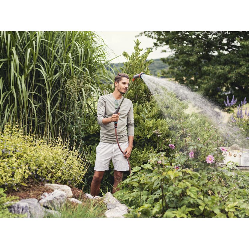 Person gießt mit Comfort Giessstab Pflanzen im Garten.