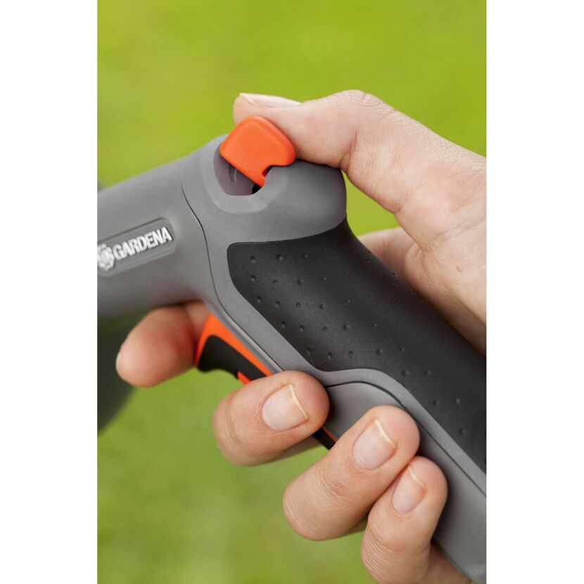 Hand drückt den orangefarbenen Knopf einer GARDENA Reinigungsspritze