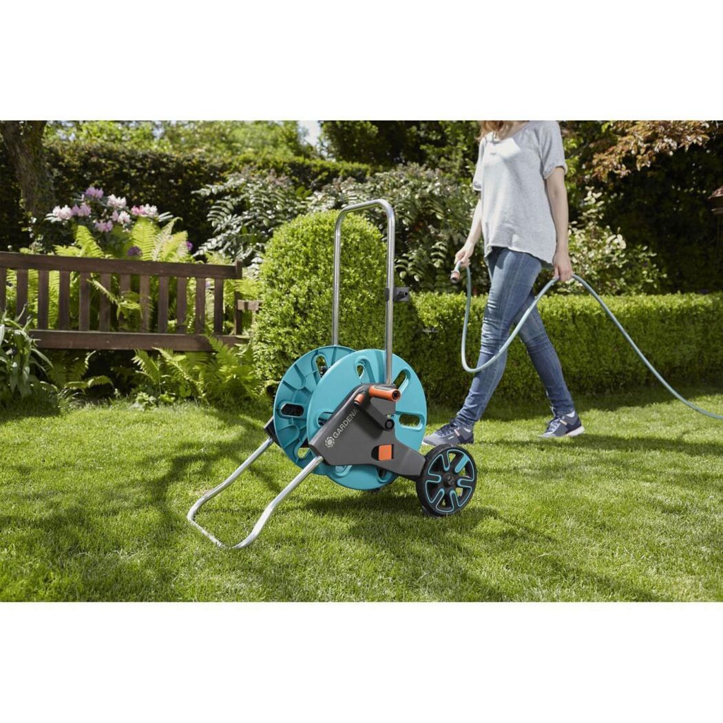 Person verwendet Schlauchwagen CleverRoll M von GARDENA.