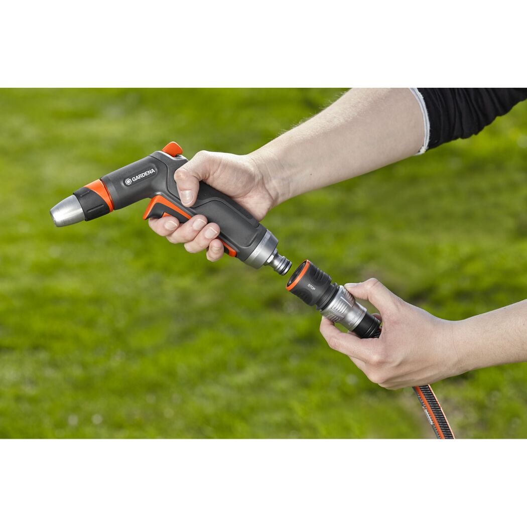 Person hält GARDENA Reinigungsspritze und Schlauchverbinder