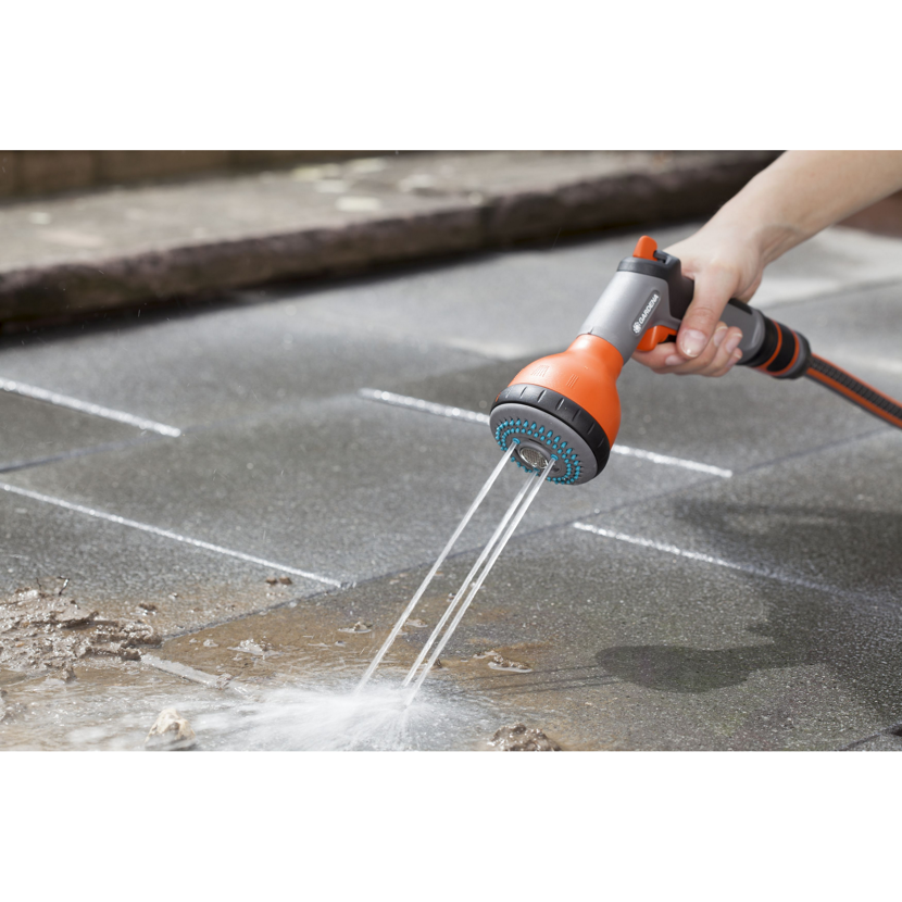 Person reinigt Steinplatten mit GARDENA Multifunktionsbrause