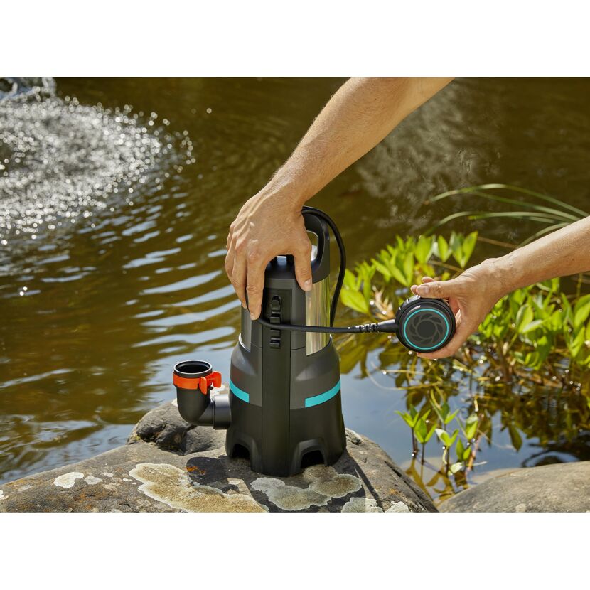 Person installiert Schmutzwasserpumpe am Teich