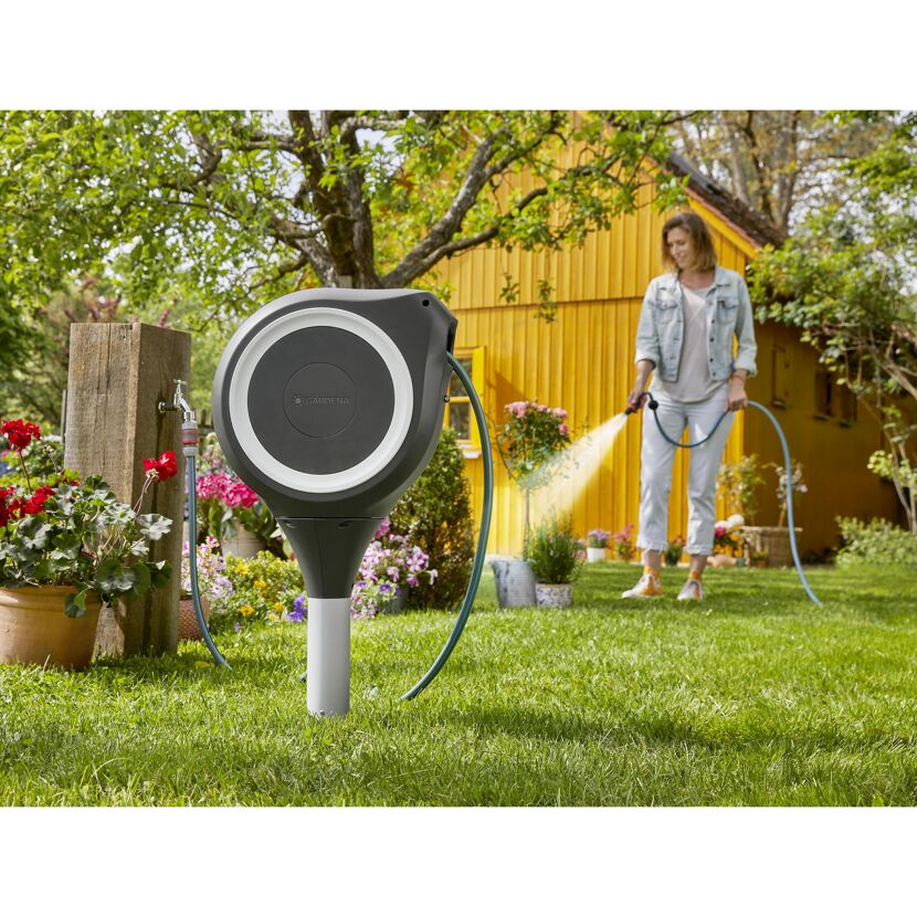 Person bewässert den Garten mit Schlauchbox RollUp S