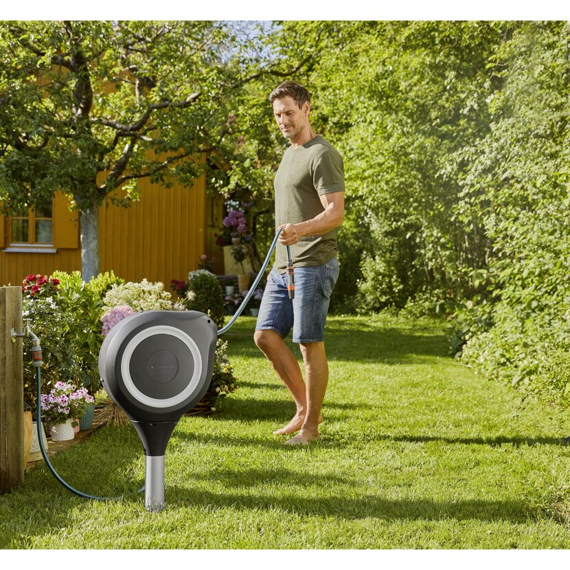 Person verwendet Schlauchbox RollUp M von GARDENA.