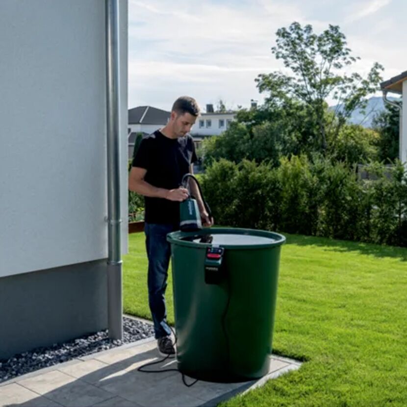 Person verwendet Akku-Tauchpumpe TP18 LTX2200 mit Regentonne