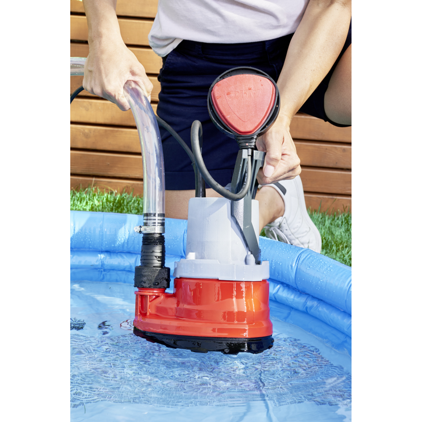 Person benutzt Tauchpumpe im Pool