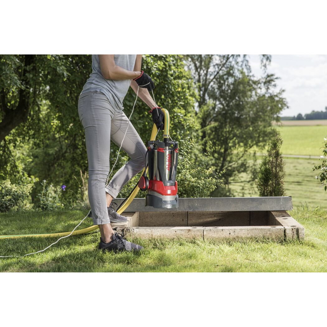Person mit Tauchpumpe am Schacht