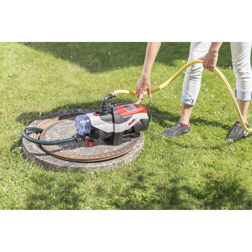Person mit Gartenpumpe und Schlauch