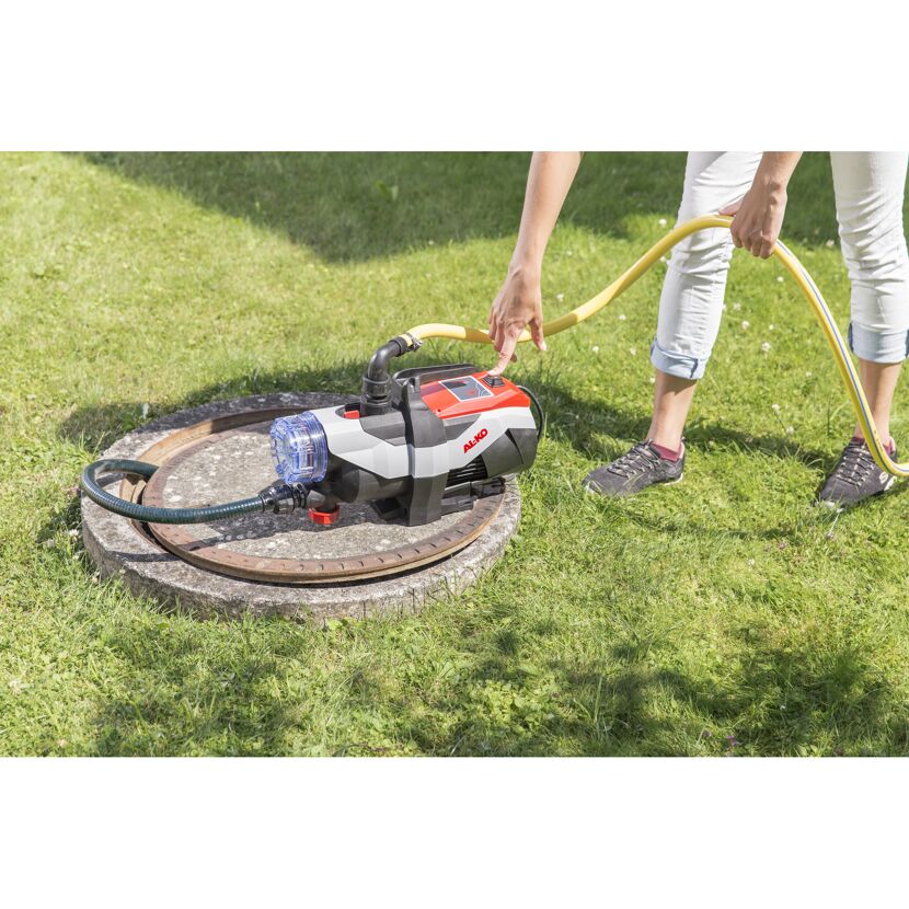 Person mit Gartenpumpe und Schlauch