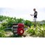 Person gießt Garten mit Benzinmotorpumpe