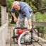 Person startet Benzinmotorpumpe