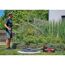 Person gießt mit Gartenpumpe