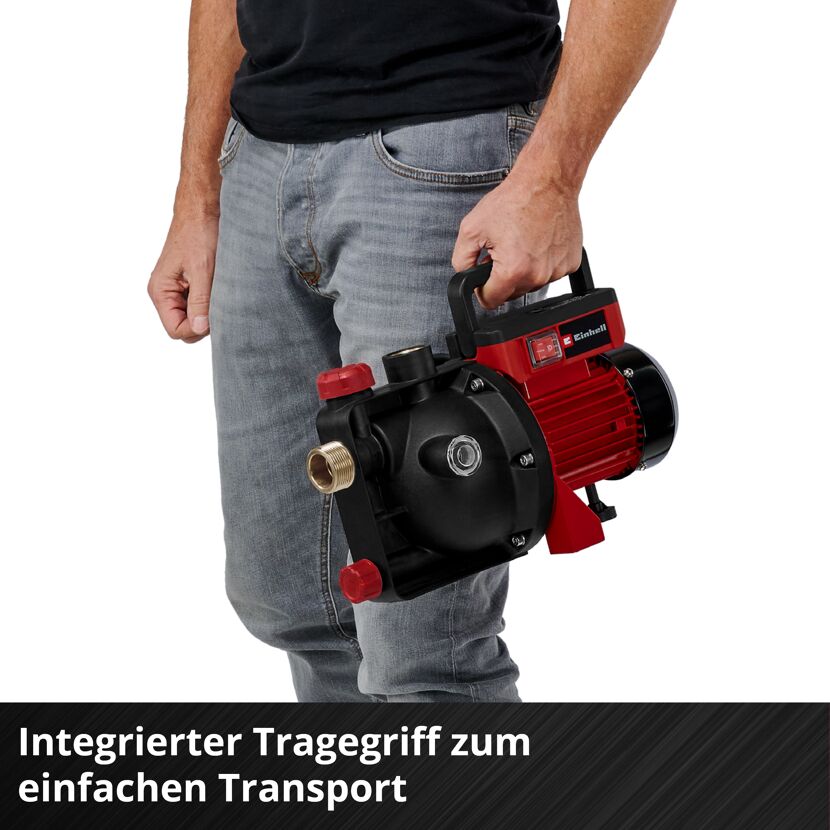 Person trägt Gartenpumpe am Tragegriff