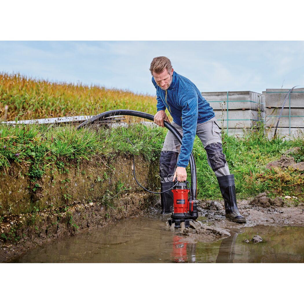 Person pumpt Wasser aus Schlammgrube