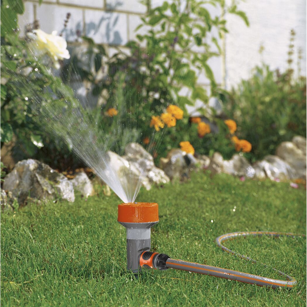 Vierflächenregner im Rasen sprüht Wasser