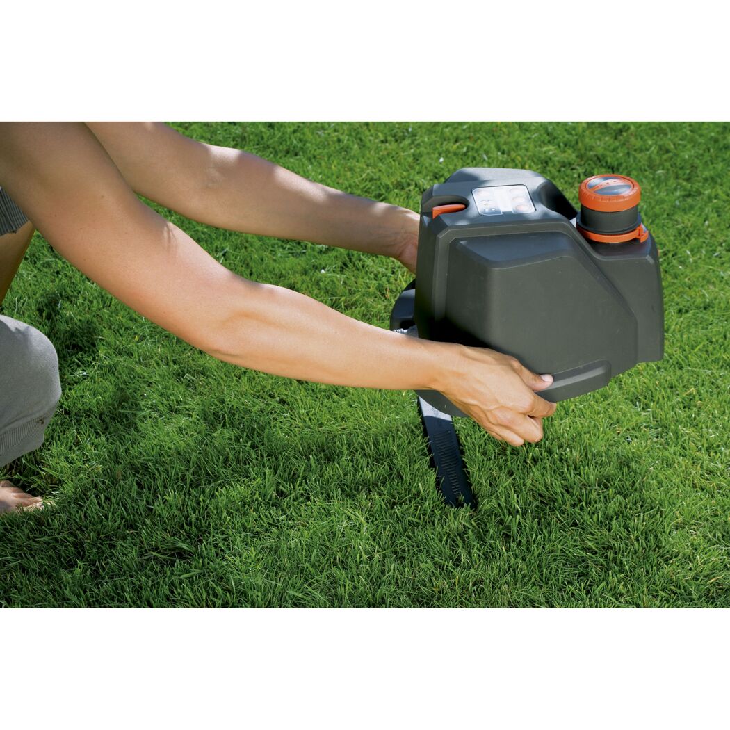 Person positioniert einen GARDENA Vielflächenregner AquaContour automatic.