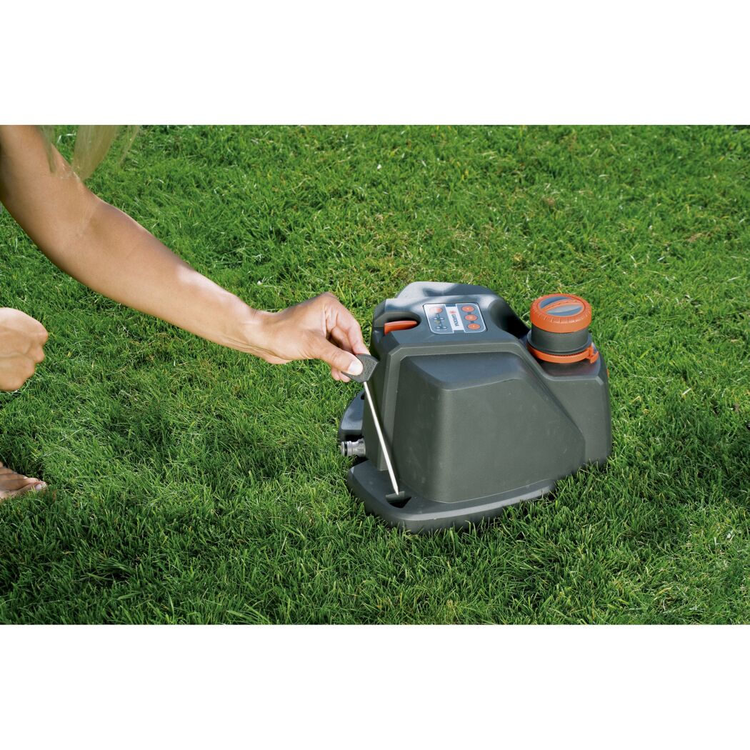 Person programmiert einen GARDENA Vielflächenregner.