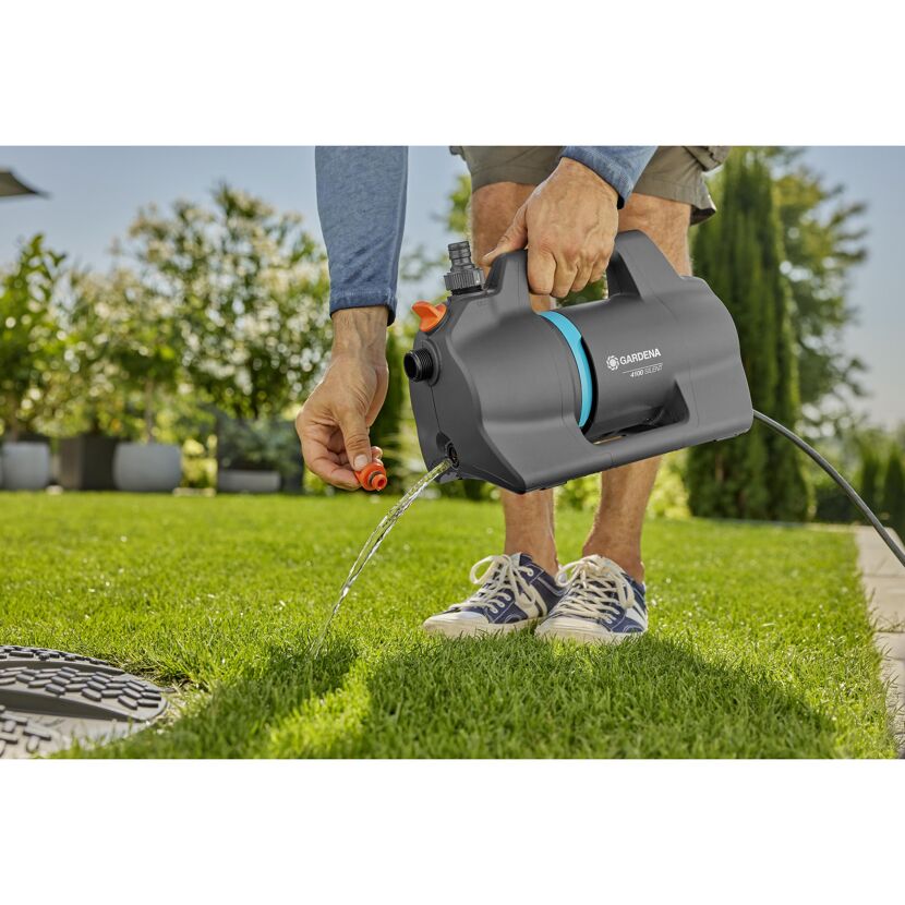 Person gießt mit der GARDENA Gartenpumpe 4100 Silent Rasen.