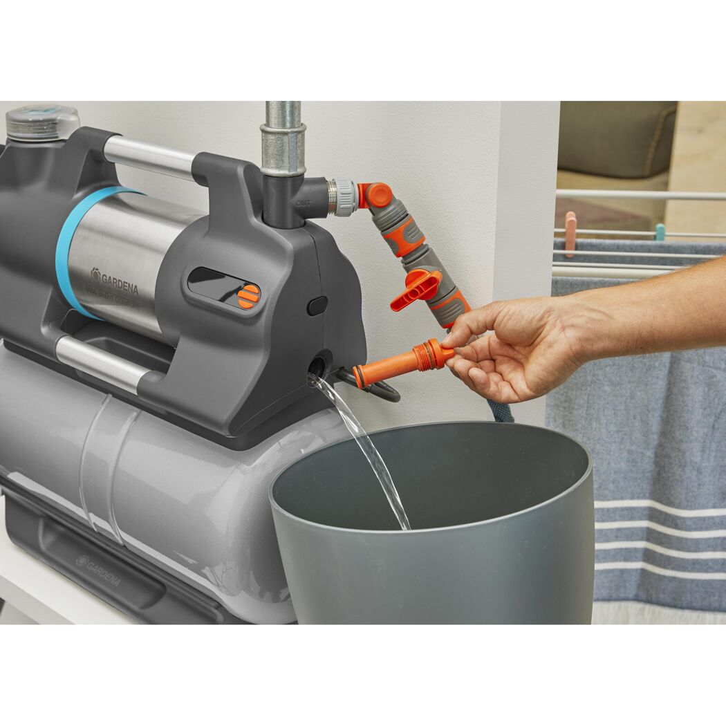 Person befüllt einen Eimer mit Wasser aus einem Hauswasserwerk.