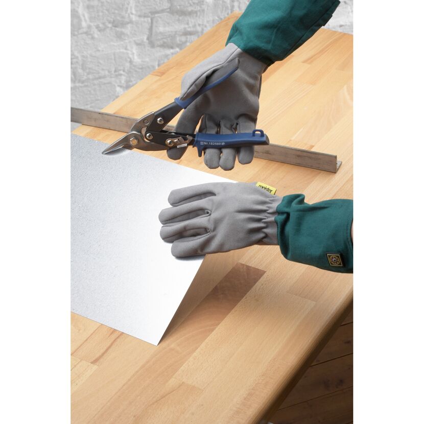 Person schneidet Blech mit Blechscheren