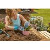 Person pflanzt Blumen mit Gartenhandschuhen ein