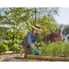 Person jätet mit Gartenhandschuhen Unkraut
