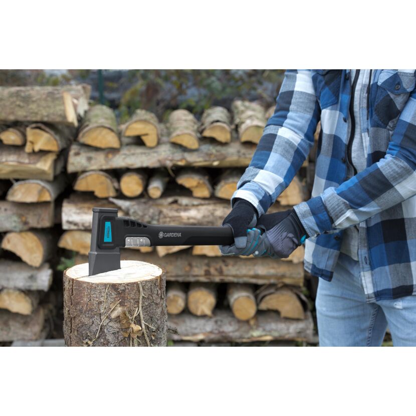 Person hackt mit einer Axt Holz.