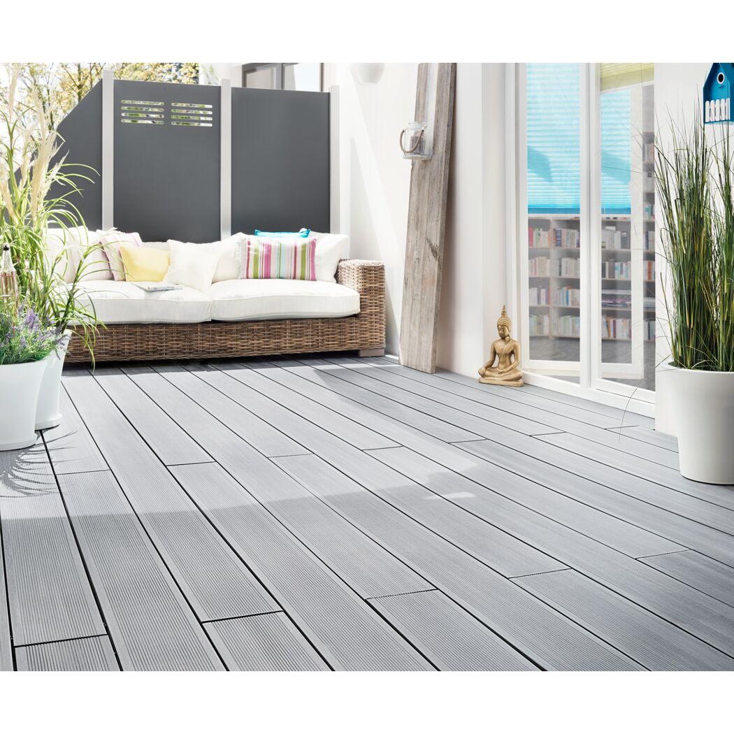 Graue Holzterrasse mit Lounge-Möbeln, Buddha-Figur und Pflanzenkübeln