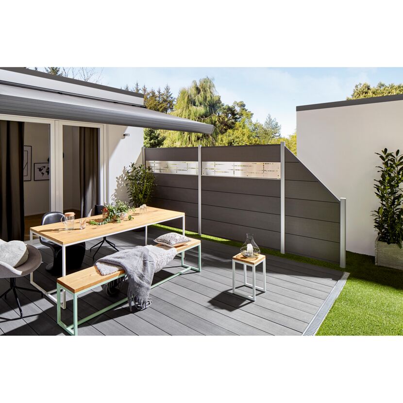 Holztisch mit Stühlen und Sichtschutz auf Terrasse
