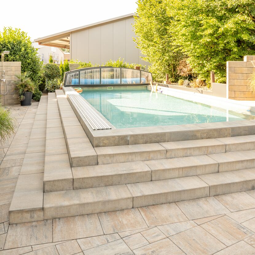 Blockstufen muschelkalkfarben als Treppe zum Pool.