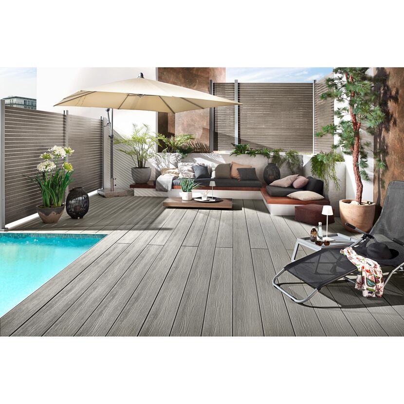 Poolbereich mit grauen Dielen, Sonnenschirm, Gartenmöbeln, Pflanzen und Deko