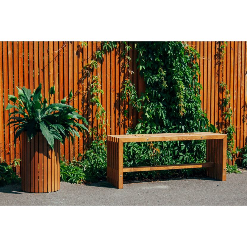 Holzbank und Blumentopf vor Holzzaun