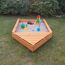 Hölzerner Sandkasten mit Spielzeug