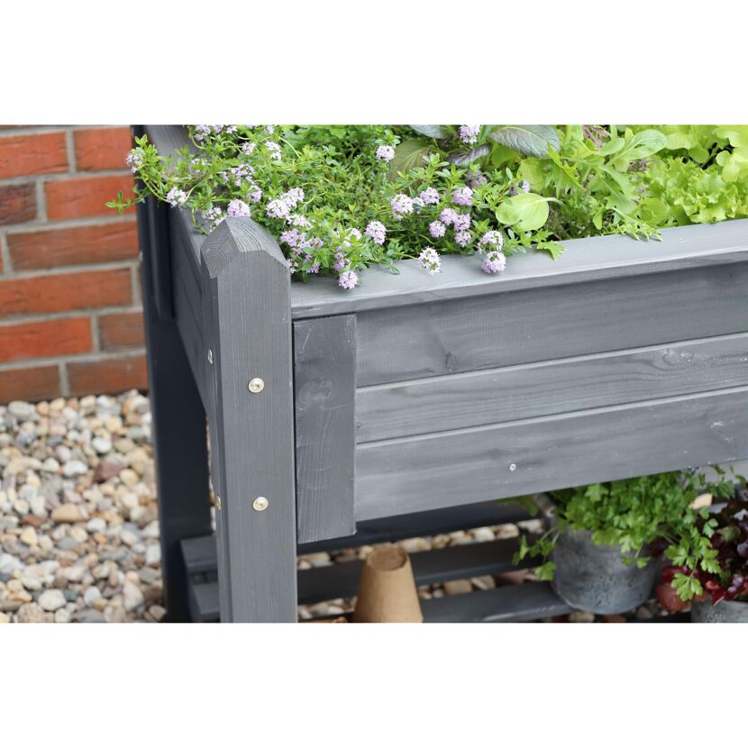 Graues Hochbeet aus Holz mit Kräutern