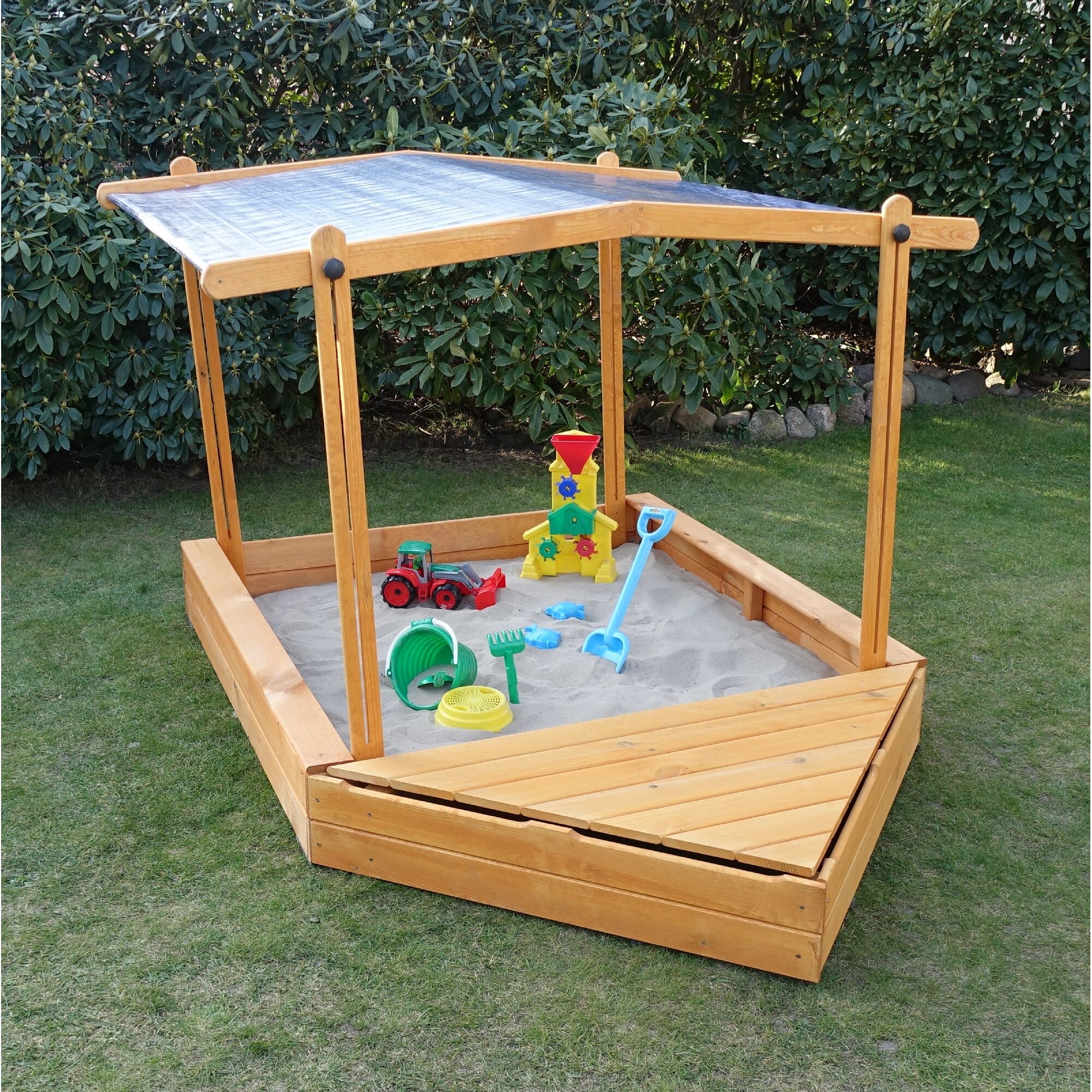 Hölzerner Sandkasten mit Dach und Spielzeug